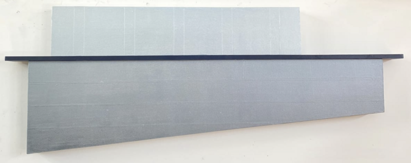 The image shows a minimalist artwork by McCain McMurray titled "Construction 205". It features a long horizontal canvas or panel with a gradient of grey hues, overlaid by a darker strip that creates a visual divide. The artwork plays with texture and subtle tonal variations, emphasizing linearity and simplicity. The piece measures 17.5 inches high, 48 inches wide, and 2.75 inches deep, and was created in the year 2022.